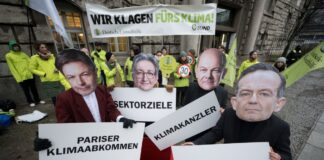 Aktivisten mit Masken von Politiker*innen stehen vor dem Oberverwaltungsgericht Berlin.