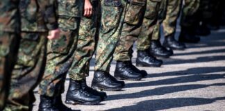 Bundeswehrsoldaten stehen auf einem Platz.