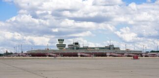 Ein Zaun aus Holz ist um die Abfertigungshallen und den Tower des ehemaligen Flughafens Berlin-Tegel gezogen.