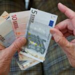 Eine ältere Frau zählt Geld.