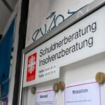 Eine Schuldnerberatung und Insolvenzberatung der Caritas ist an einem Eingang in der Schönhauser Allee in Pankow ausgeschildert.