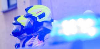 Feuerwehrleute stehen an einem Einsatzort.