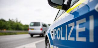 Ein Streifenwagen der Polizei steht auf einer Straße.