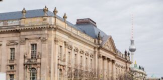 Der Berliner Fernsehturm ragt hinter der Staatsbibliothek Unter den Linden hervor.