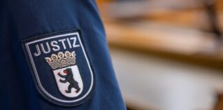 Ein Abzeichen mit dem Wort «Justiz» und dem Landeswappen von Berlin ist an der Uniform eines Justizvollzugsbeamten im Kriminalgericht Moabit angebracht.