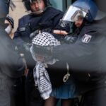 Eine der propalästinensischen Besetzerinnen der HU wird von Polizisten aus dem Gebäude gebracht.