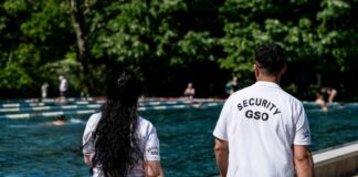 Security-Mitarbeiter laufen im Sommerbad Kreuzberg am Rand des Sportbeckens.