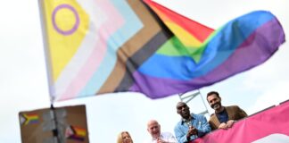 Berlins Queerbeauftragter, Alfonso Pantisano (r), steht bei der Berlin Pride-Parade auf einem Wagen.