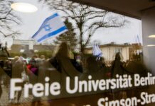 Eine Israel-Flagge spiegelt sich in einer Scheibe der Freien Universität Berlin.
