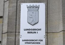 Ein Schild weist auf das Landgericht Berlin an der Fassade zum Kriminalgericht Moabit hin.