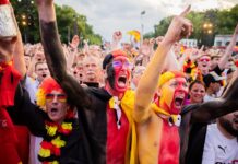 Deutschland-Fans jubeln in der Fanzone am Brandenburger Tor vor dem Anpfiff.