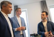 Krankenpfleger Orhan Erkin Altinörs (r) zeigt Finanzsenator Stefan Evers (CDU, M) und SPD-Fraktionschef Raed Saleh seine Werkswohnung.