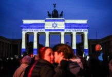 Das Brandenburger Tor in Berlin leuchtet am ersten Jahrestag des Terrorangriffs der Hamas auf Israel in den Farben der israelischen Flagge.