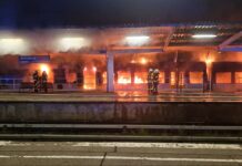 Einsatzkräfte der Feuerwehr löschen den Brand eines Zuges im S-Bahnhof Ahrensfelde.