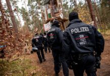 Polizeikräfte sperren ein Waldgebiet, in dem das Tesla-Protestcamp in Grünheide bei Berlin liegt.