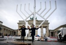 Rabbiner Yehuda Teichtal (l) und Rabbi Shmuel Segal tanzten bei der Einweihung des nach Veranstalterangaben größten Chanukka-Leuchters Europas auf dem Pariser Platz am Montag. (Archivbild)