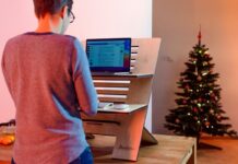 Mann arbeitet an seinem Computertisch vor einer weihnachtlichen Tanne. Foto: unsplash/standsome