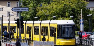 Eine Straßenbahn fährt in den gesicherten Bereich an der gesperrten Brücke an der Wuhlheide im Ortsteil Oberschöneweide. 