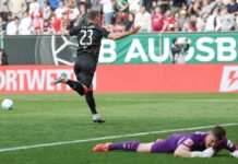 Berlins Matchwinner Andrej Ilic läuft nach seinem Siegtor jubelnd vor den Union-Fanblock. Augsburgs Torwart Finn Fahmen liegt geschlagen am Boden.