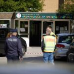 Polizisten stehen vor einer Schule im Berliner Bezirk Spandau, an der es einen Messerangriff gab.