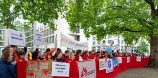 Mitarbeiter von Hilfsorganisationen demonstrieren in Berlin für mehr Hilfsgüter in Gaza.  