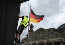 Die Aufbauarbeiten laufen: Ein Arbeiter befestigt eine Plane zur Vorbereitung einer Projektion anlässlich des 30. Jahrestags der Reichstag-Verhüllung.