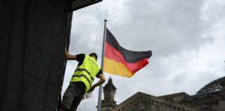 Die Aufbauarbeiten laufen: Ein Arbeiter befestigt eine Plane zur Vorbereitung einer Projektion anlässlich des 30. Jahrestags der Reichstag-Verhüllung.