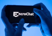 Eine Frau hält ein Smartphone mit dem Logo des Krypto-Messengerdienstes Encrochat. (Symbolbild) 