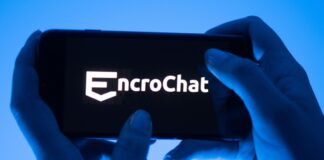 Eine Frau hält ein Smartphone mit dem Logo des Krypto-Messengerdienstes Encrochat. (Symbolbild) 