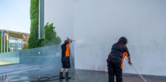 Reinigungskräfte arbeiten an Fassade und Boden am Kanzleramt.