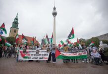 Menschen nehmen an einer propalästinensischen Kundgebung unter dem Motto «Solidarität mit Palästina - Stoppt den Gaza Genozid» am Neptunbrunnen teil. 