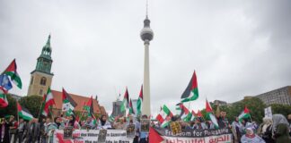 Menschen nehmen an einer propalästinensischen Kundgebung unter dem Motto «Solidarität mit Palästina - Stoppt den Gaza Genozid» am Neptunbrunnen teil. 