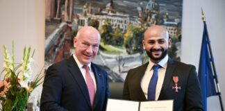 Kai Wegner hat Yousef Ayoub das Bundesverdienstkreuz samt Urkunde überreicht. 