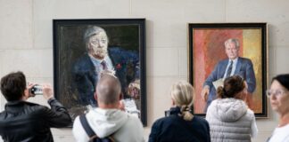 Menschen stehen am Tag der offenen Tür der neuen Bundesregierung im Kanzleramt vor den Porträts der ehemaligen Kanzlern Schmidt (l) und Brandt.