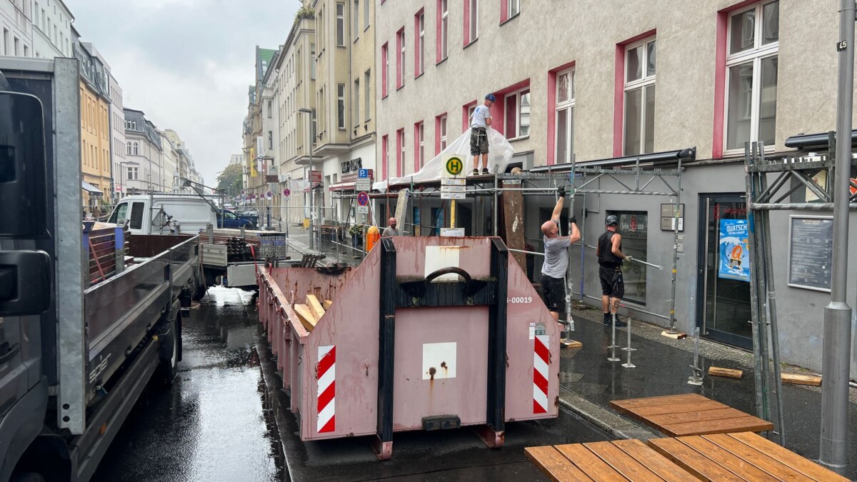 Beschädigtes Dach an Haus in Berlin An einem Haus mit einem beschädigten Dach wird ein Schutztunnel für Fußgänger aufgestellt.