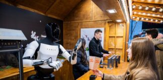 Tesla zeigt Optimus-Roboter in Berlin Der humanoide Roboter «Optimus» von Tesla verteilt bei seiner Vorstellung in der Mall of Berlin Popcorn an eine Besucherin.