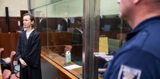 Haftstrafe für mutmaßlichen IS-Unterstützer – gefordert Der angeklagte mutmaßliche IS-Unterstützer verfolgt die Verhandlung im Gerichtssaal hinter einer Glasscheibe.