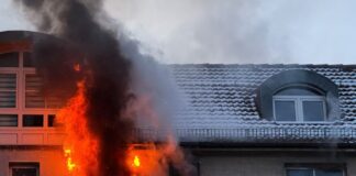 Feuerwehr rettet mehrere Menschen vor Brand Feuer schlägt während eines Brandes aus dem Fenster eines Hauses.