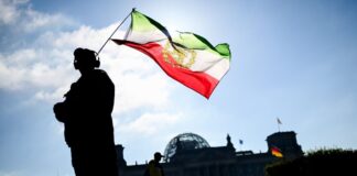 Hunderte demonstrieren für Reza Pahlavi und Umsturz im Iran Mit dem Emblem des Schahs: Ein Demonstrant in Berlin.