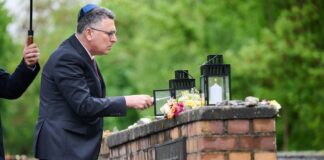 Israels Außenminister Gideon Saar zündet bei seinem Besuch am Mahnmal "Gleis 17" eine Kerze an.