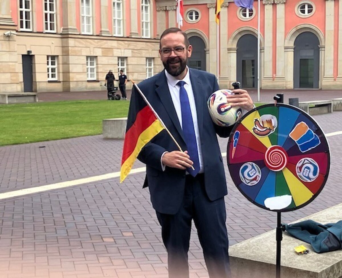 Sportminister Gordon Hoffmann Aktion zur Fußball-WM: Brandenburgs Sportminister Gordon Hoffmann (CDU) dreht vor dem Landtagsgebäude an einer Art Glücksrad für ein WM-Gewinnspiel für Sportvereine.