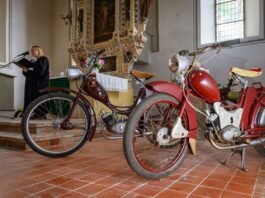 DDR-Mopeds in Kirche: Simson-Gemeinde feiert Zusammenhalt Pfarrerin Susanne Noack spricht in der Kirche - neben ihr die Kult-Mopeds.