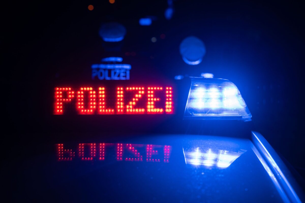 Polizisten vor Blaulicht Ein Mann entkam zunächst. (Symbolbild)