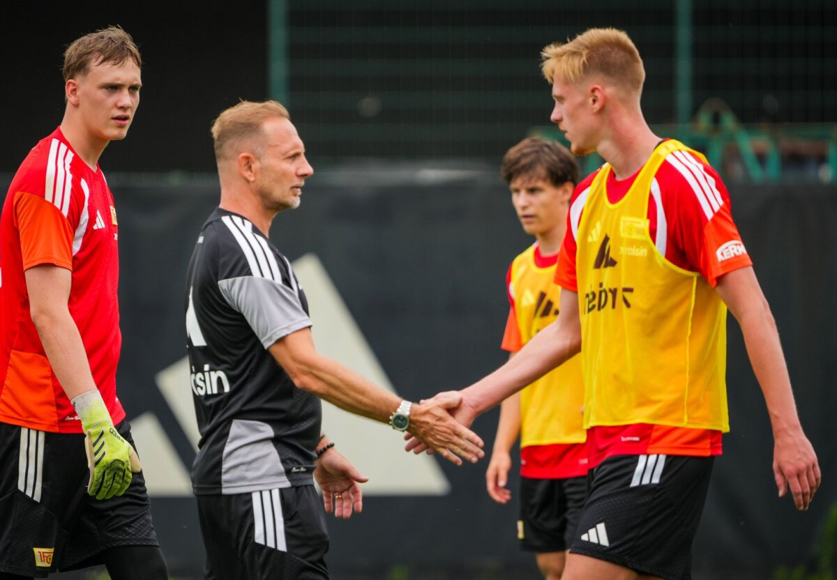 Training 1. FC Union Berlin Neuzugänge unter sich: Union-Trainer Mauro Lustrinelli (M) klatscht Zeno van den Bosch ab (r)