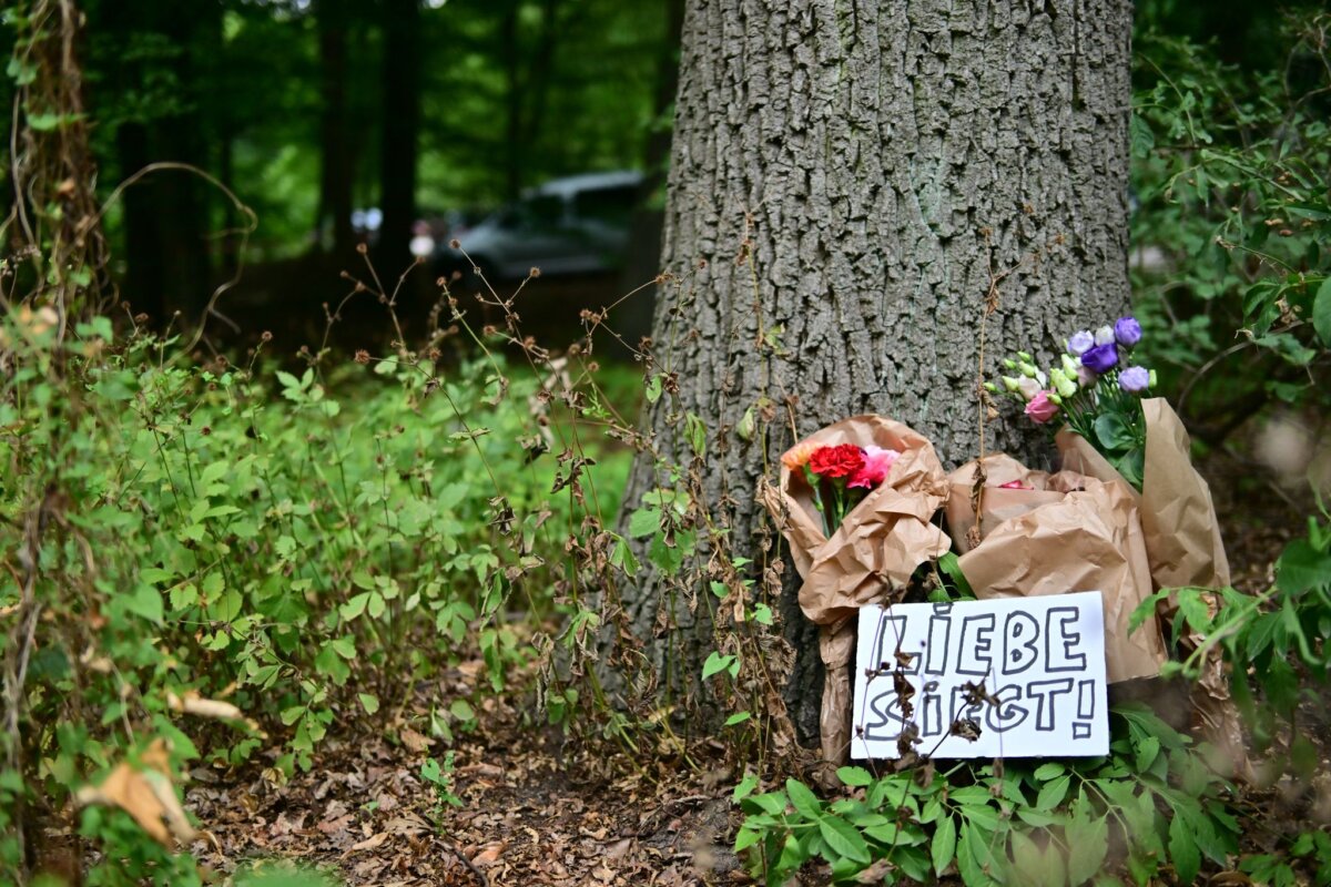 Auto rast in Menschenmenge - CSD abgebrochen Ein Schild mit der Aufschrift "Liebe siegt!" liegt vor Blumen an einem Baum, nahe einem abgesperrten Bereich des Tiergartens, wo ein Fahrzeug einen Baum gerammt hatte.