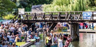 Geschmückte Kähne ziehen im Korso durch Spreewälder Fließe Füße im Wasser und auf dem Kahn wird getanzt: So wird in Lübbenau entspannt die Kahnparade gefeiert.