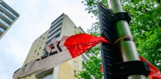 Augenzeugen zu Hochhaussturz von Sechsjährigem gesucht Am Morgen nach dem Sturz hängt noch Absperrband der Polizei an einem Mast.