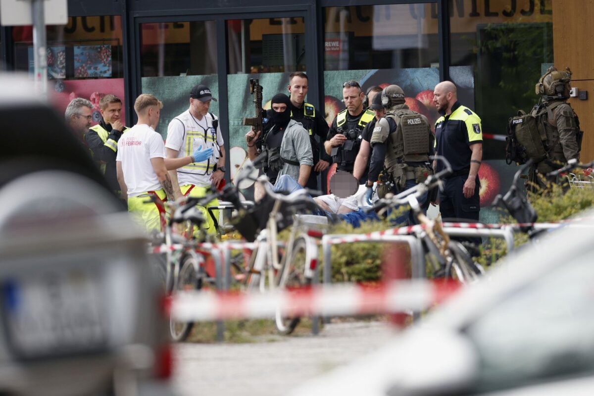 Ermittlungen zu Geiselnahme in Berliner Supermarkt Einsatzkräfte stehen nach der Geiselnahme vor dem Supermarkt in Berlin neben einer verletzten Person auf einer Trage. (Archivbild)