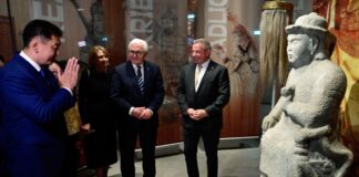 Mit dem Staatsgast zu Dschingis Khan – Ausstellung eröffnet Der mongolische Präsident Ukhnaagiin Khurelsukh (l) verneigt sich vor einer Steinstatue in der James-Simon-Galerie in Berlin.