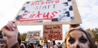 Teilnehmer halten Schilder hoch mit verschiedenen Protestparolen während der Kundgebung unter dem Motto «Gen Z regelt»